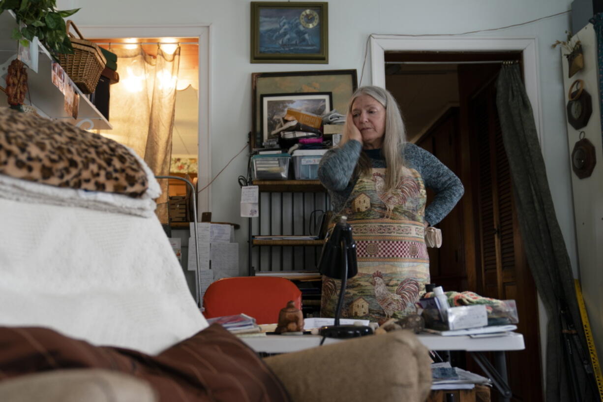 FILE - Nancy Rose, who contracted COVID-19 in 2021 and continues to exhibit long-haul symptoms including brain fog and memory difficulties, pauses while organizing her desk space, Tuesday, Jan. 25, 2022, in Port Jefferson, N.Y. Rose, 67, said many of her symptoms waned after she got vaccinated, though she still has bouts of fatigue and memory loss. A report from the Centers for Disease Control and Prevention released on Wednesday, May 25, 2022, found that up to a year after an initial coronavirus infection, 1 in 4 adults aged 65 and older had at least one potential long COVID health problem, compared with 1 in 5 younger adults.