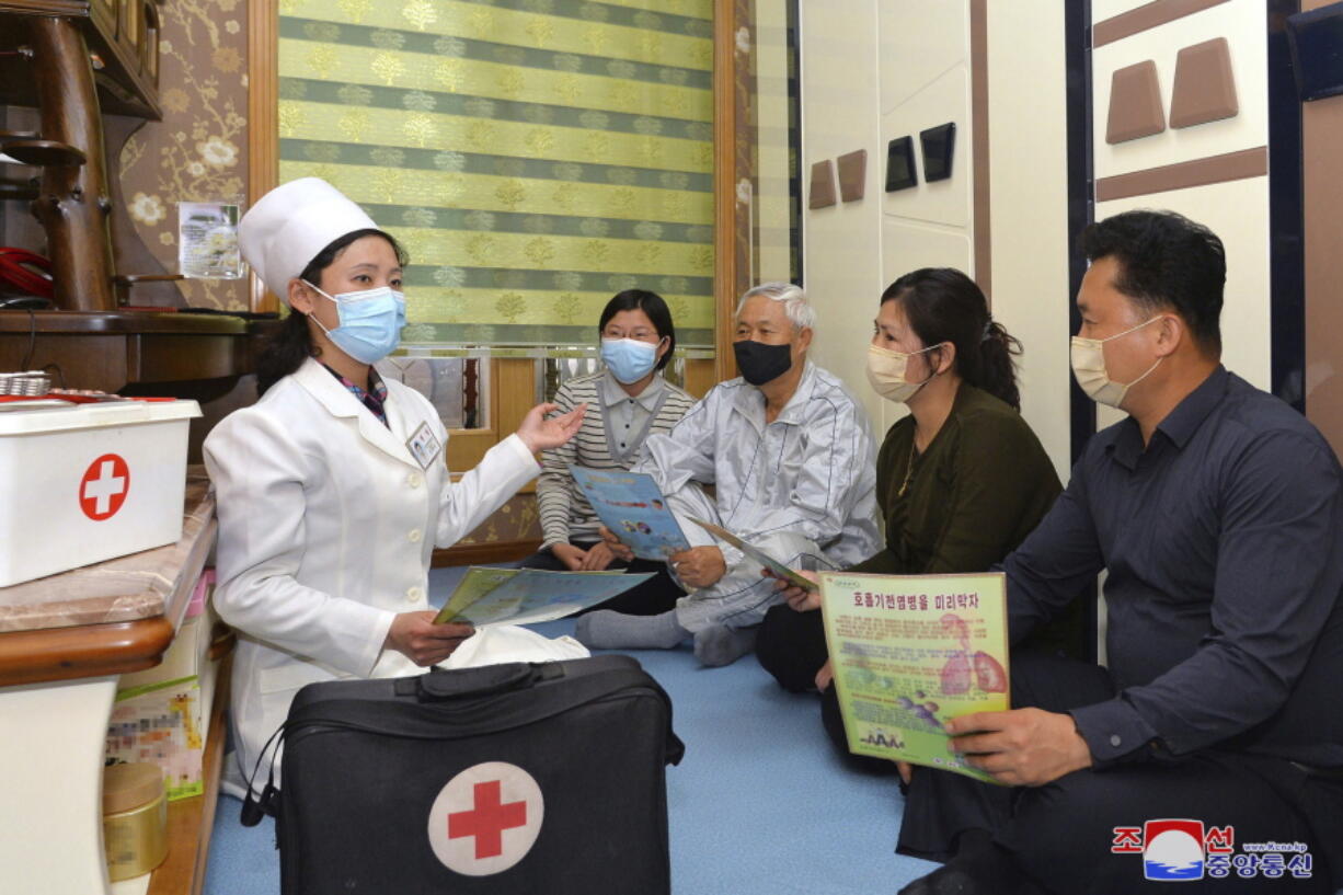In this photo provided by the North Korean government, a doctor visits a family during an activity to raise public awareness of the COVID-19 prevention measures, in Pyongyang, North Korea Tuesday, May 17, 2022.  Independent journalists were not given access to cover the event depicted in this image distributed by the North Korean government. The content of this image is as provided and cannot be independently verified. Korean language watermark on image as provided by source reads: "KCNA" which is the abbreviation for Korean Central News Agency.