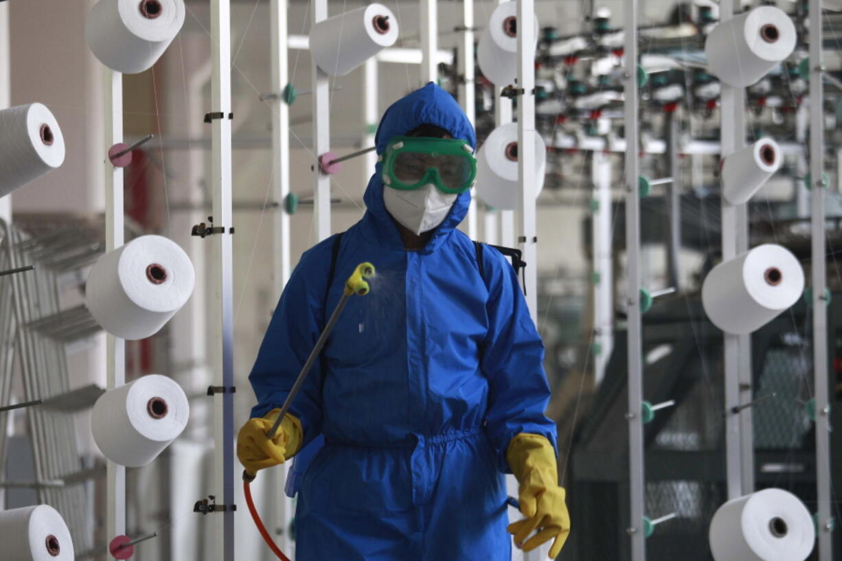 An employee of Songyo Knitwear Factory in Songyo district disinfects the work floor in Pyongyang, North Korea, Wednesday, May 18, 2022, after Kim Jong Un said Tuesday his party would treat the country's outbreak under the state emergency. North Korea said Wednesday more than a million people have already recovered from suspected COVID-19 just a week after disclosing an outbreak it appears to be trying to manage in isolation as global experts express deep concern about the public health threat.