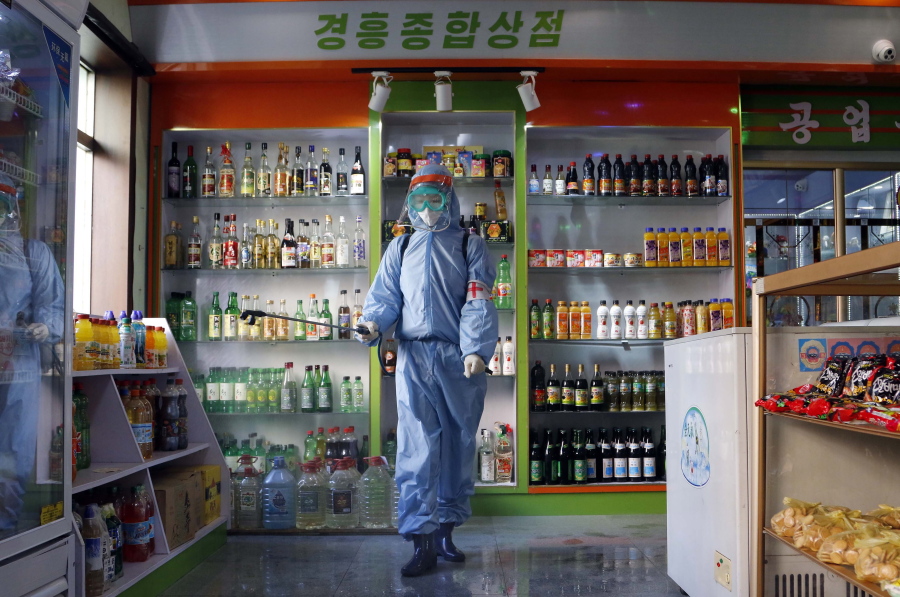 FILE - An employee of the Kyonghung Foodstuff General Store disinfects the showroom in Pyongyang, North Korea, Wednesday, Nov. 10, 2021. Before acknowledging domestic COVID-19 cases, Thursday, May 12, 2022, North Korea spent 2 1/2 years rejecting outside offers of vaccines and steadfastly claiming that its superior socialist system was protecting its 26 million people from "a malicious virus" that had killed millions around the world.