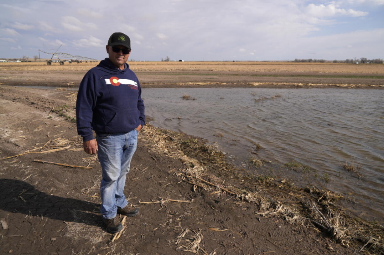 Don Schneider stands in front of an augmentation pond on his property Friday, April 29, 2022, in Ovid, Colo. He pumps water from a shallow aquifer for irrigation, and uses supply from the South Platte River to replenish the wells.