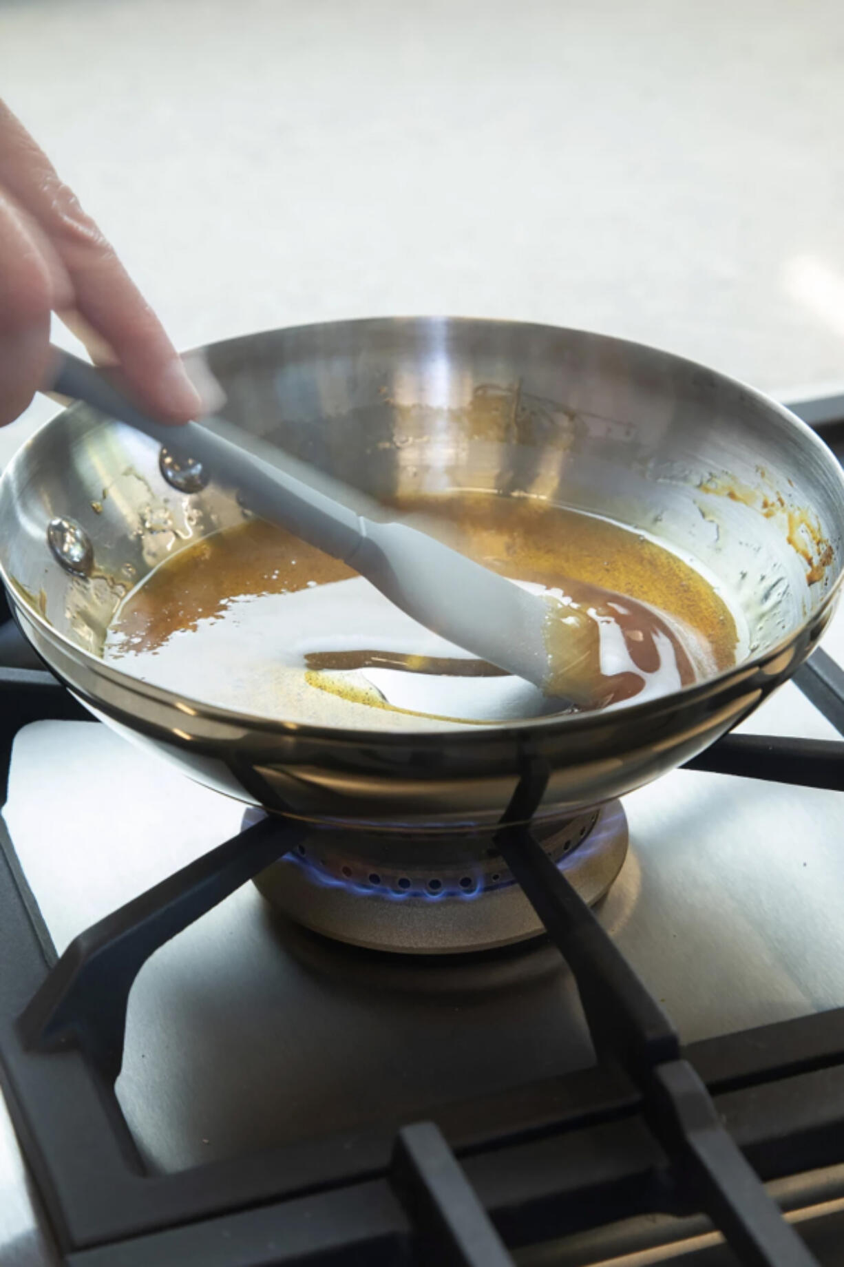 Cooking columnist Ben Mims caramelizes sugar to test the difference between the gas burner and electric induction stovetop. (Myung J.
