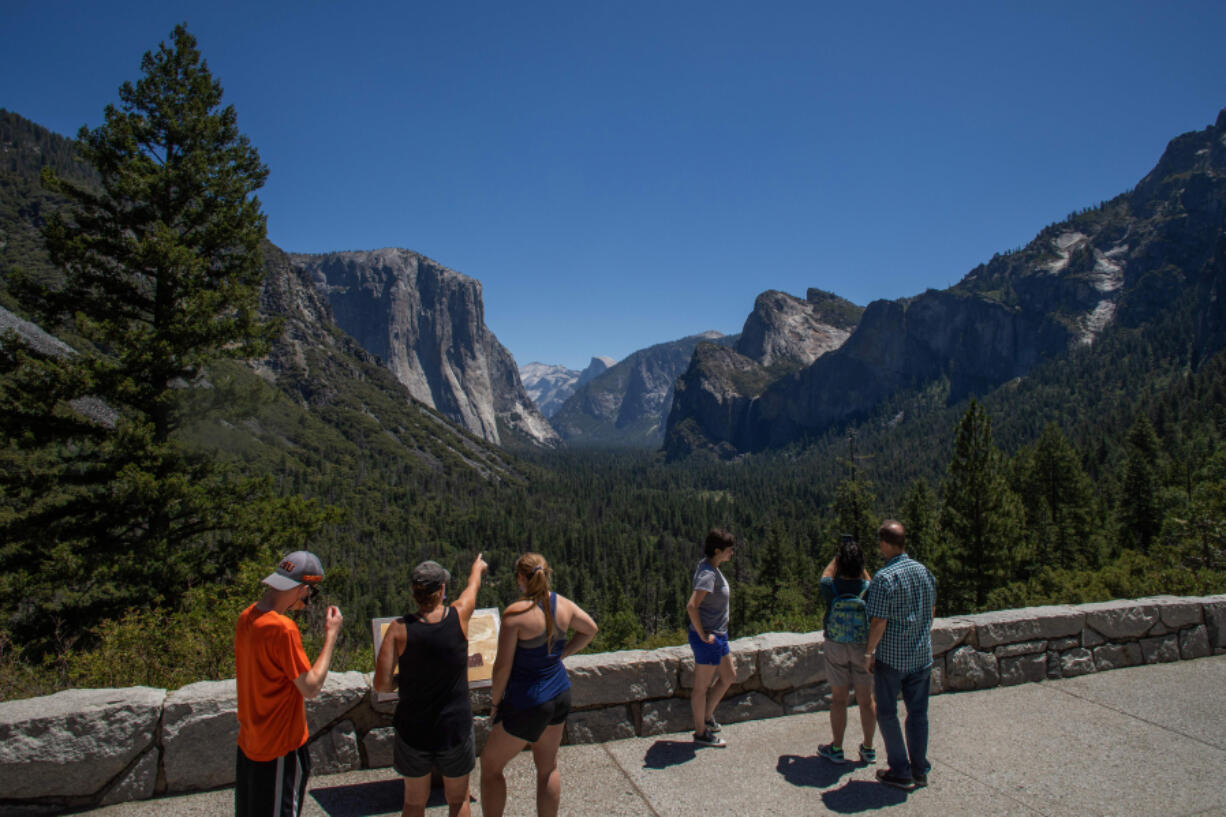 Visitors walk to the Tunnel View lookout in Yosemite Valley at Yosemite National Park, Calif., on July 8, 2020.