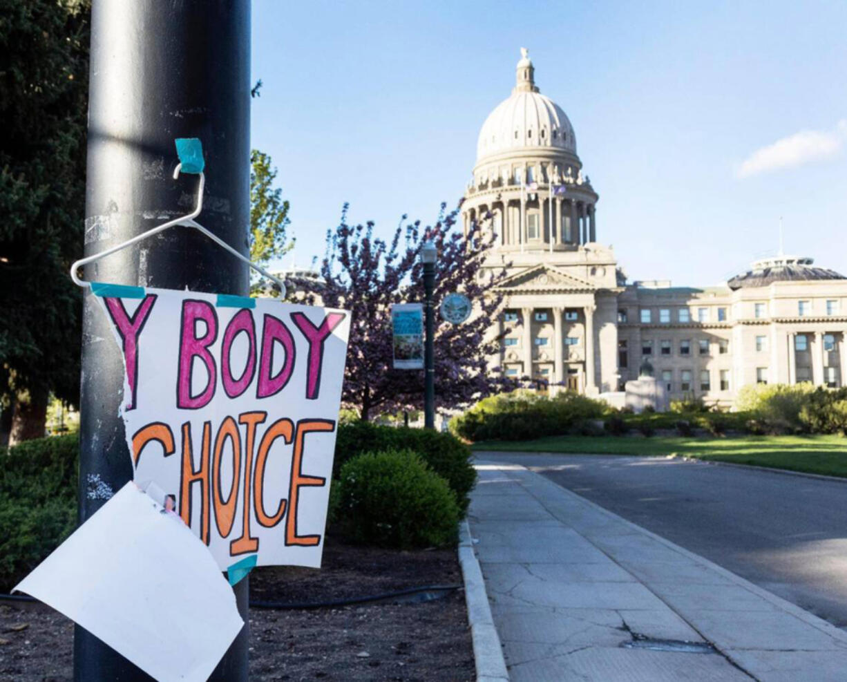 In this photo from May 3, 2022, a sign is taped to a hanger taped to a streetlight in front of the Idaho Capitol. (Sarah A.