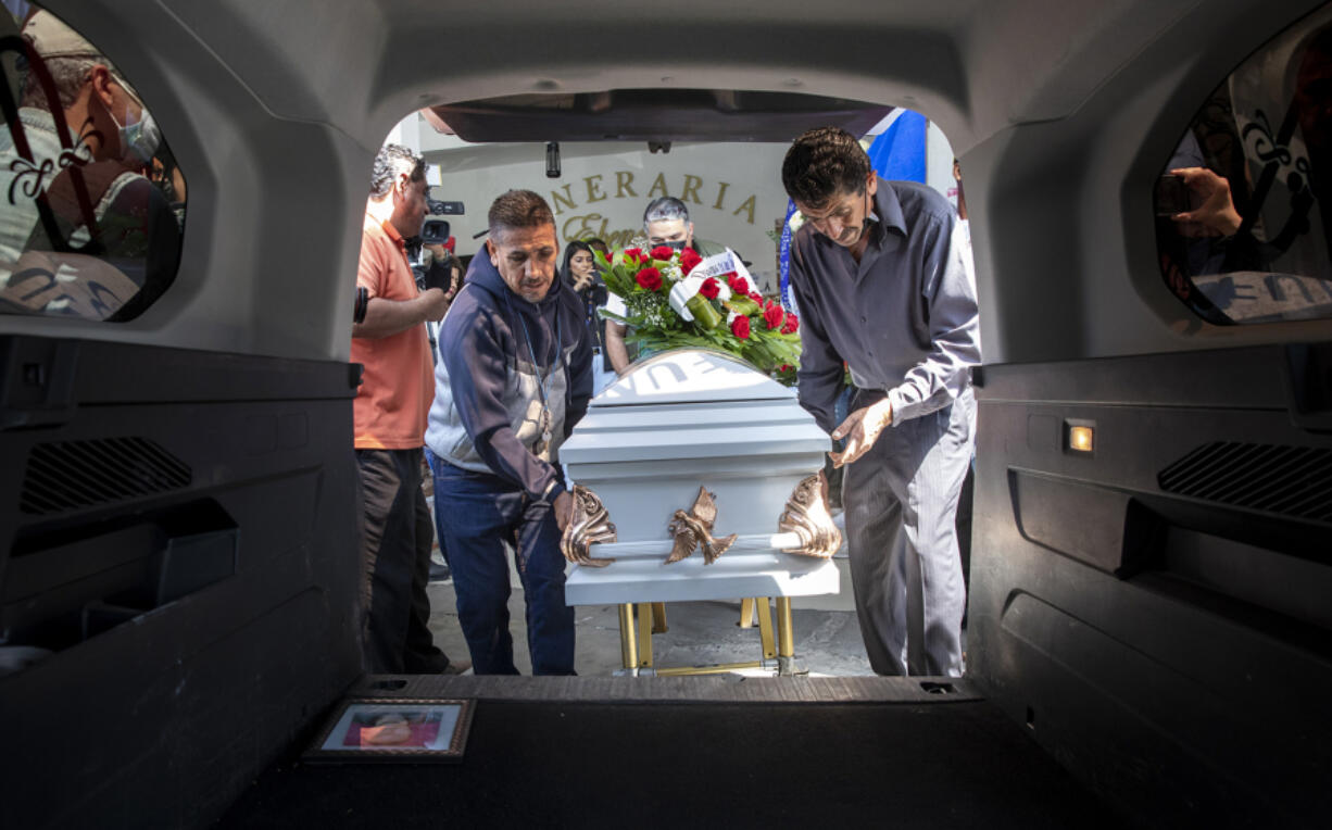 Two men place the casket of Jocelyn Anselme, 34, in a hearse on Thursday, June 2, 2022.