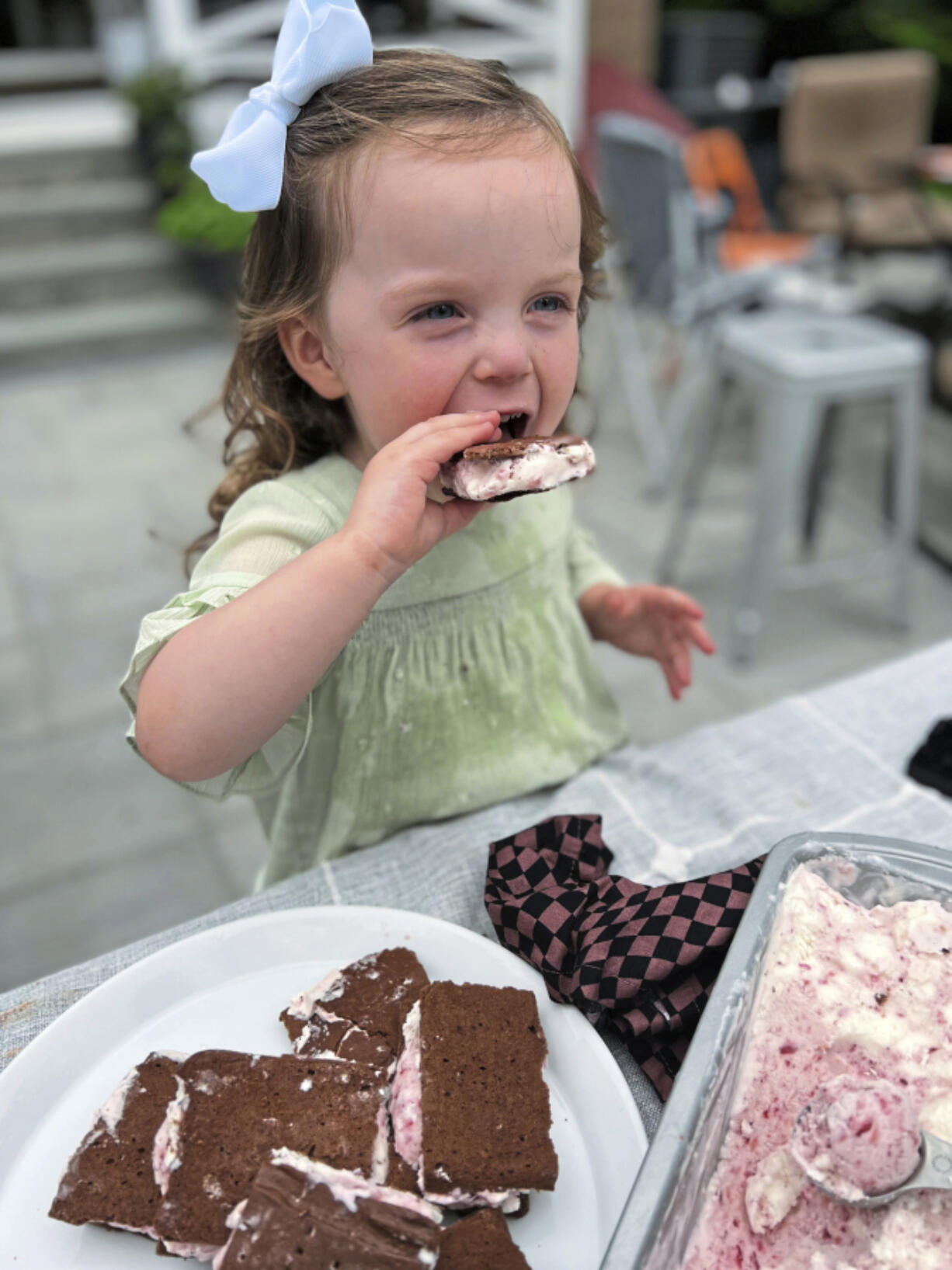 Greta McKay, 2, enjoys a homemade ice cream sandwich filled with no-churn strawberry ice cream.