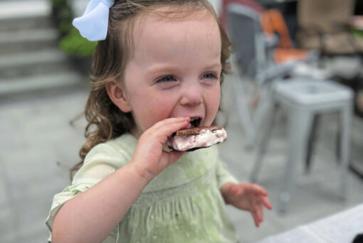 Greta McKay, 2, enjoys a homemade ice cream sandwich filled with no-churn strawberry ice cream.
