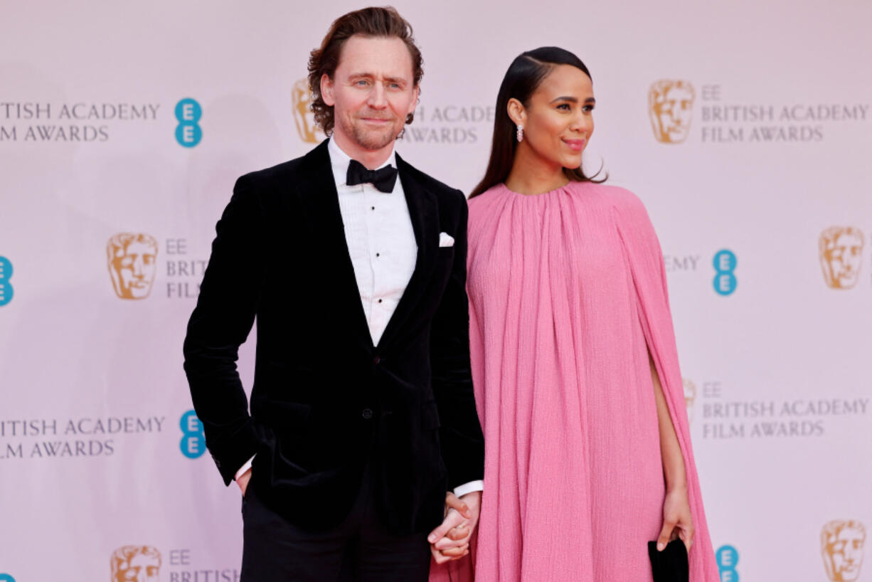 Tom Hiddleston, left, and Zawe Ashton pose on the red carpet upon arrival at the BAFTA British Academy Film Awards at the Royal Albert Hall in London on March 13, 2022.
