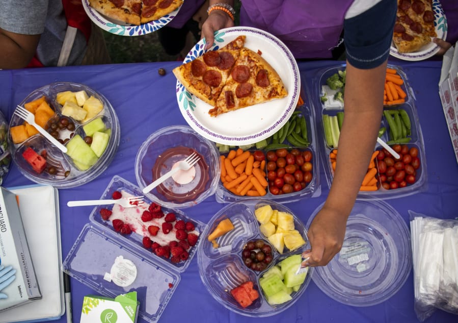 Kids grab lunch at a site serving meals during the summer in 2019. Share will provide meals at a variety of schools through the summer.