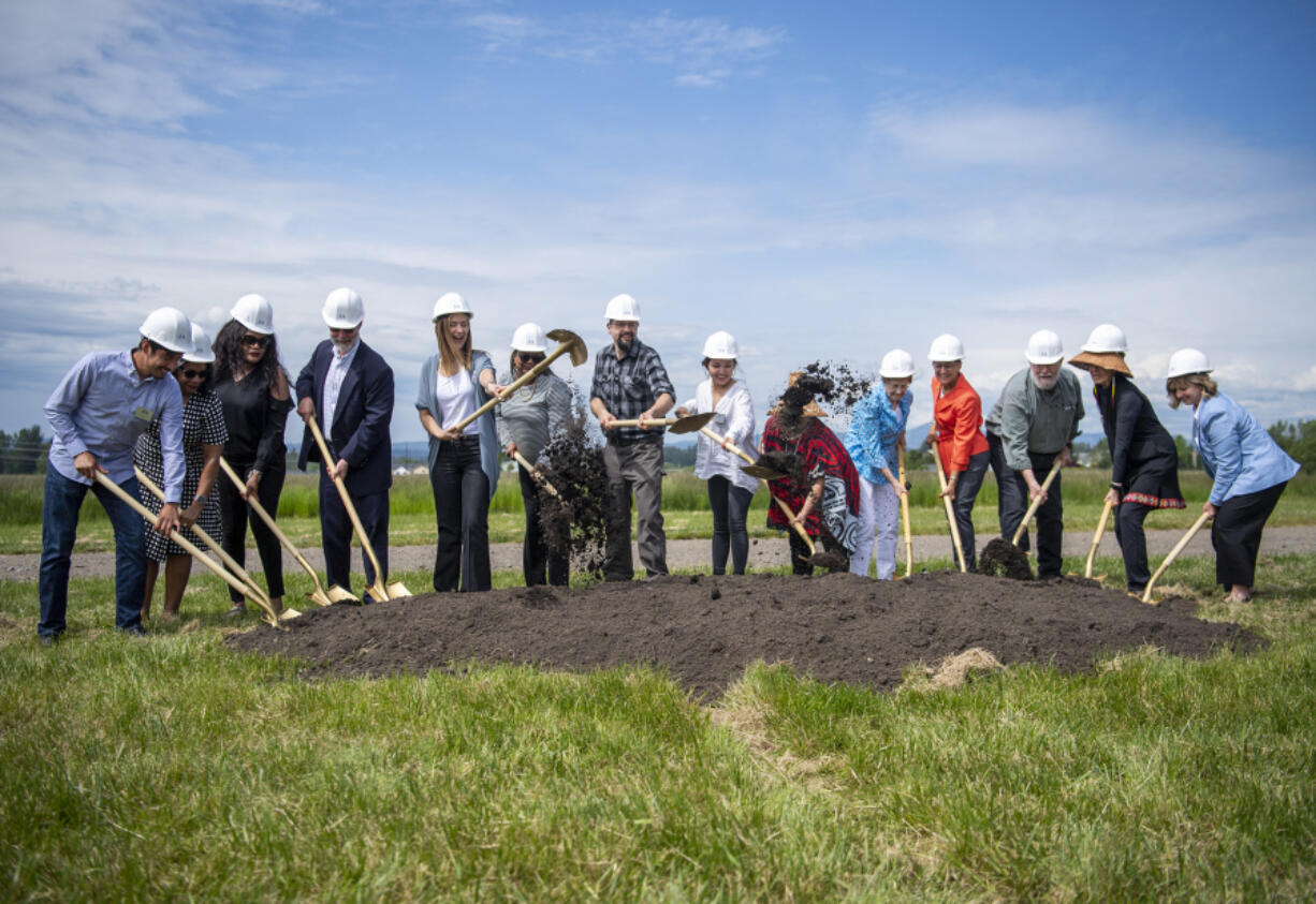 Delegates from the Cowlitz Tribe, Clark College and the city of Ridgefield shovel dirt on Wednesday as part of a groundbreaking ceremony at the future site of Clark College's Boschma Farms campus in Ridgefield.