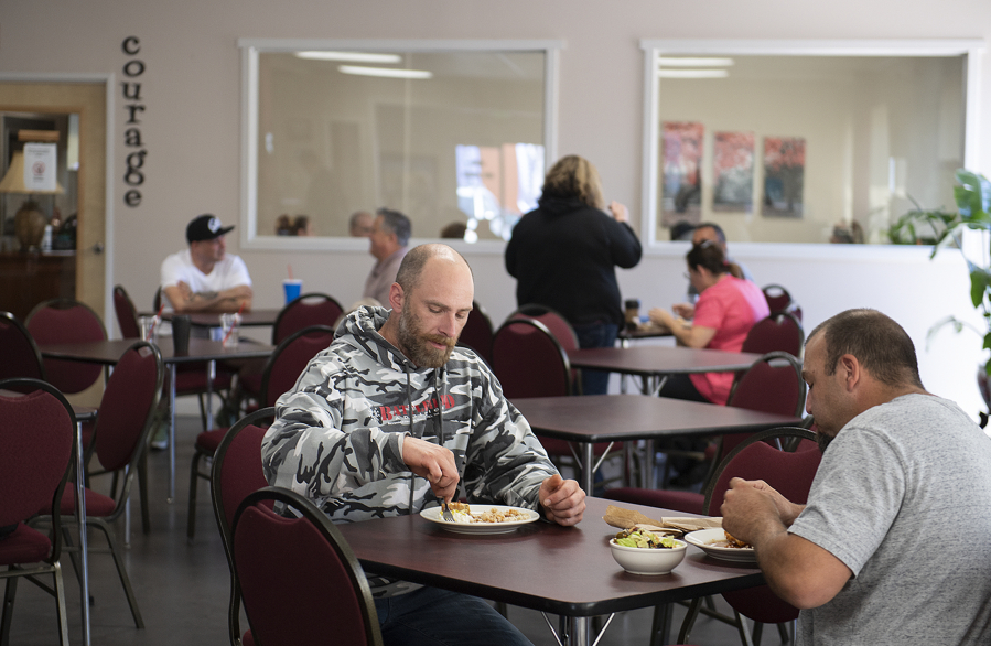 Recovery Cafe Clark County member Chris Mackmer, left, enjoys lunch with volunteer Scott Hacker. Recovery Cafe is a community organization that specializes in helping people with addiction recovery. It is part of a collection of local organizations that have banded together to respond to Clark County's opioid crisis.