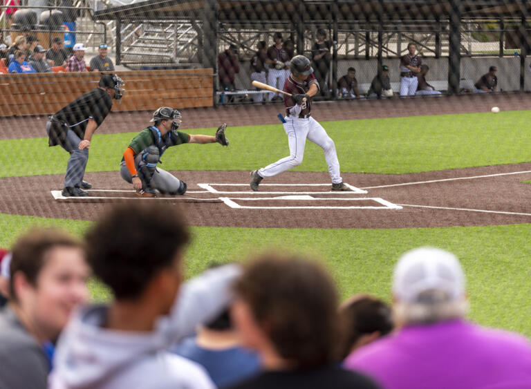 Raptors batter Jeff Lodes, right, swings at a pitch Wednesday, June 1, 2022, during an exhibition game between the Ridgefield Raptors and the Cowlitz Black Bears at the Ridgefield Outdoor Recreation Complex.