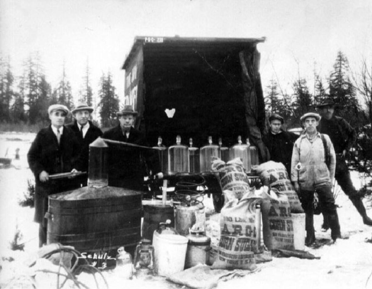 Standing amid confiscated liquor in this 1927 photo, Sheriff Lester Wood, third from left, and five men examine the haul. Wood was one of four law officers who died from gunshot wounds enforcing prohibition laws forced on them by the 18th Amendment.