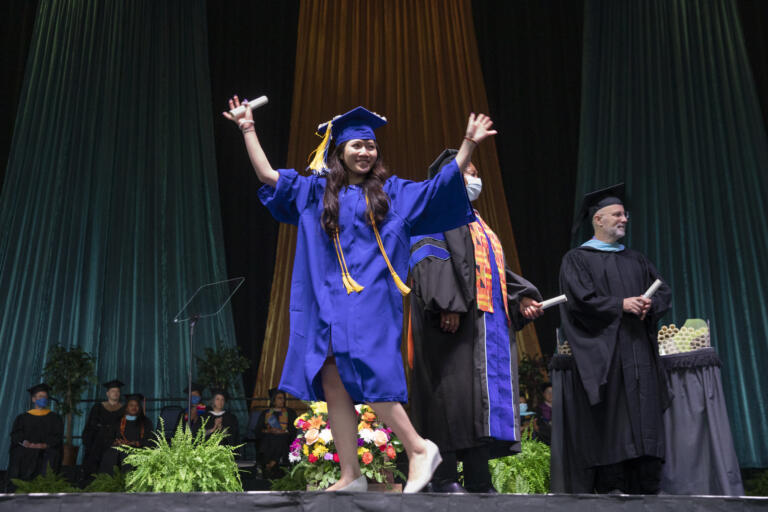 Graduate Vanessa Huynh waves while crossing the stage at the Clark College Commencement ceremony on Thursday, June 16, 2022, at the RV Inn Style Resorts Amphitheater.