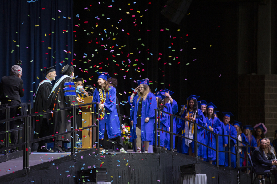 Graduates cross the stage to receive their diplomas as confetti falls Thursday at the Clark College commencement ceremony.