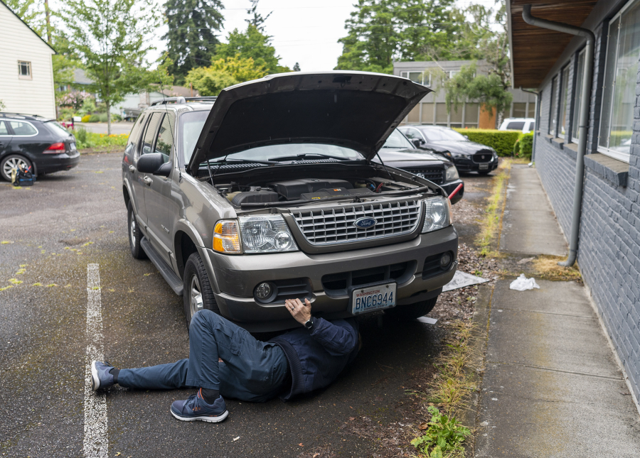 Brightside Roadside Service owner Bryan Munnick changes the oil on a Ford Explorer. He was connected through the customer through Oili, an app from a Vancouver-based developer that allows customers to schedule oil changes at their homes.