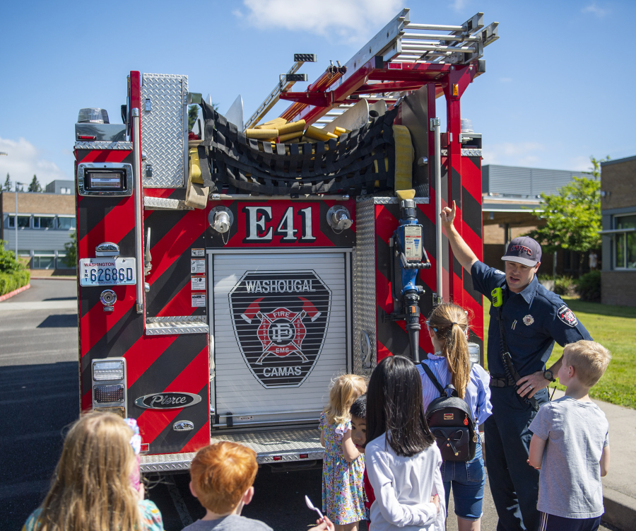 Camas-Washougal Fire Department firefighter Trevor Guay shows off a fire truck to a group of kids Wednesday at Hellen Baller Elementary.