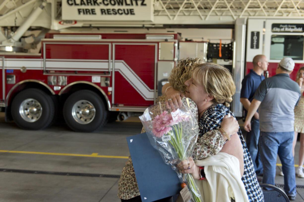 Tiffany Martell, left, hugs Denise Yurecko a La Center High School office assistant who used an automated external defibrillator to save Martell's son's life. Triston Martell, then a 15-year-old sophomore, collapsed at La Center High School on May 26 and was saved by five of the school's employees. Clark-Cowlitz Fire Rescue on Thursday honored those employees for their lifesaving efforts.