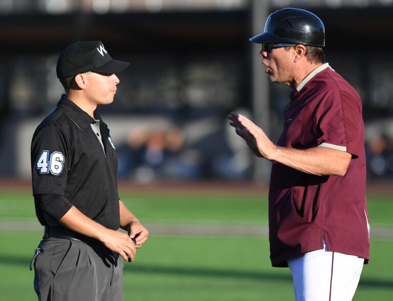 Raptors head coach Chris Cota, right, talks to an umpire about a call Friday, June 24, 2022, during a game between Ridgefield and the Victoria HarbourCats at the Ridgefield Outdoor Recreation Complex.
