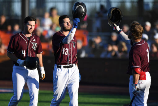 Raptors left fielder Alex Sepulveda, center, celebrates with third baseman Travis Welker, right, after Sepulveda hit a two-run home run Friday, June 24, 2022, during a game between Ridgefield and the Victoria HarbourCats at the Ridgefield Outdoor Recreation Complex.