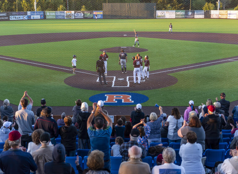 Fans celebrate as Raptors outfielder Jacob Sharp, left, comes to home plate after hitting a three-run home run Tuesday, June 28, 2022, during a game between the Ridgefield Raptors and the Portland Pickles at the Ridgefield Outdoor Recreation Complex.