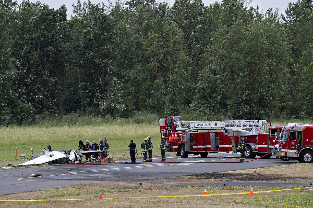 Officials look over the wreckage after a fatal plane crash at Pearson Field Airport on Tuesday morning, June 28, 2022.