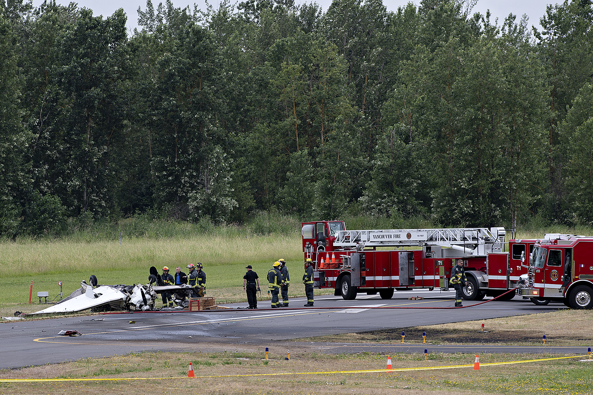 Officials look over the wreckage after a fatal plane crash at Pearson Field Airport on Tuesday morning, June 28, 2022.