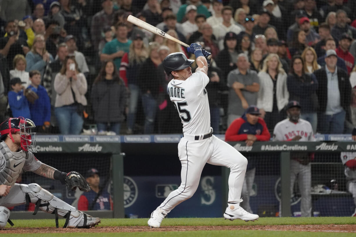 Seattle Mariners' Dylan Moore follows through on an RBI single off Boston Red Sox closing pitcher Hansel Robles during the ninth inning of a baseball game, Saturday, June 11, 2022, in Seattle. The Mariners won 7-6. (AP Photo/Ted S.