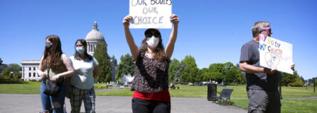 Women's rights supporters, from left, Lacy Nadeau, Carolyn Nadeau, Rebecca Rutzick and Joe Ward, all of Olympia, Wash., rally on the Capitol Campus in Olympia, Wash., Friday, June 24, 2022, following the morning's announcement of the U.S. Supreme Court's overturning of Roe v Wade.