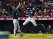 Seattle Mariners' Julio Rodriguez, right, celebrates with J.P. Crawford after they scored on a single by Kevin Padlo during the sixth inning of a baseball game Saturday, June 25, 2022, in Anaheim, Calif. (AP Photo/Mark J.