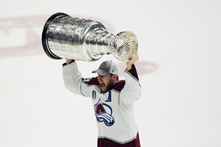 Colorado Avalanche center Nathan MacKinnon lifts the Stanley Cup after the team defeated the Tampa Bay Lightning 2-1 in Game 6 of the NHL hockey Stanley Cup Finals on Sunday, June 26, 2022, in Tampa, Fla.