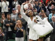 Serena Williams of the US waves as she leaves the court after losing to France's Harmony Tan in a first round women's singles match on day two of the Wimbledon tennis championships in London, Tuesday, June 28, 2022.