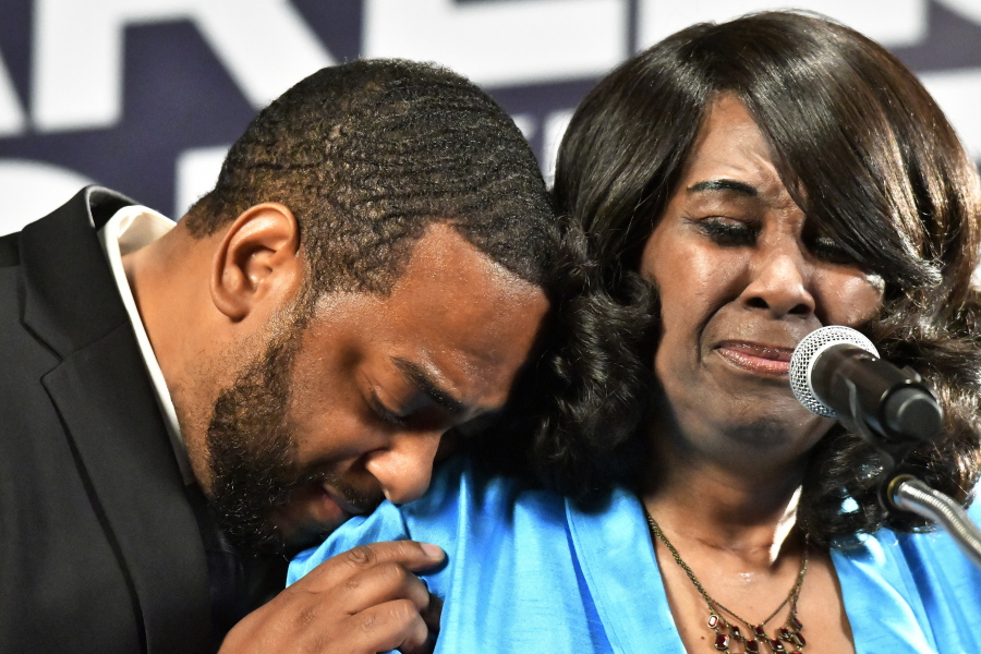 Democrat Charles Booker, left, hugs his mother, Earletta Hearn, as she speaks to a group of supporters following her son's victory in the Kentucky primary in Louisville, Ky., Tuesday, May 17, 2022. (AP Photo/Timothy D.