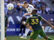 LA Galaxy forward Dejan Joveljic, left, heads the ball for a goal past Portland Timbers defender Larrys Mabiala during the second half of a MLS soccer match in Carson, Calif., Saturday, June 18, 2022. The match ended in a 1-1 tie.