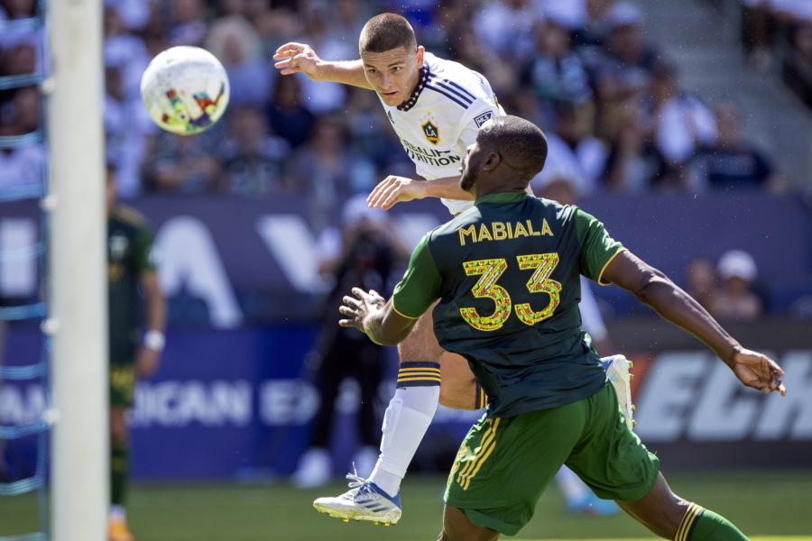 LA Galaxy forward Dejan Joveljic, left, heads the ball for a goal past Portland Timbers defender Larrys Mabiala during the second half of a MLS soccer match in Carson, Calif., Saturday, June 18, 2022. The match ended in a 1-1 tie.