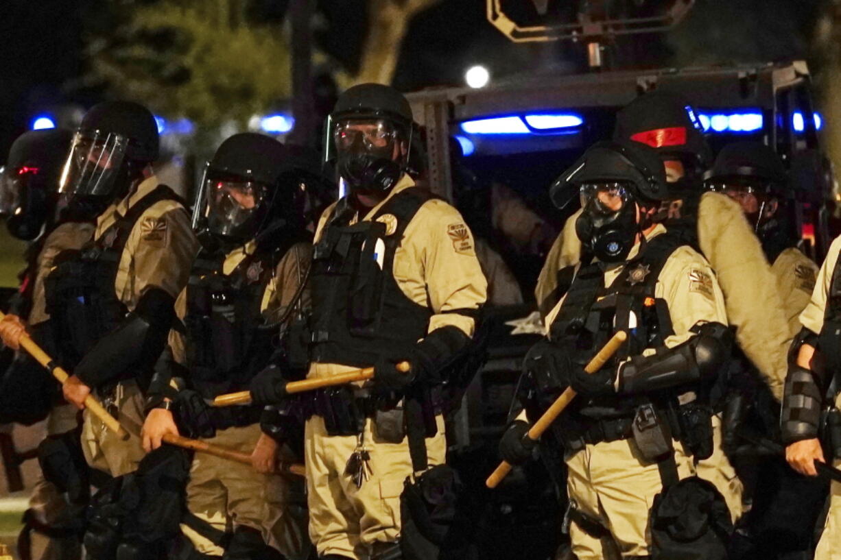 Police in riot gear surround the Arizona Capitol after protesters reached the front of the Arizona Sentate building as protesters reacted to the Supreme Court decision to overturn the landmark Roe v. Wade abortion decision Friday, June 24, 2022, in Phoenix. (AP Photo/Ross D.