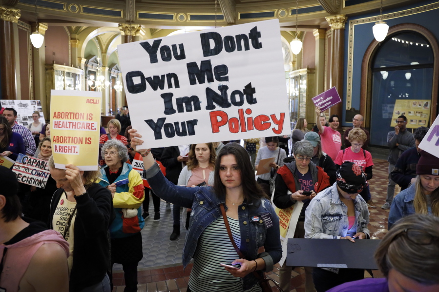 FILE - Marissa Messinger, of Lake View, Iowa, center, holds a sign during a rally to protest recent abortion bans, May 21, 2019, at the Statehouse in Des Moines, Iowa. The Iowa Supreme Court on Friday, June 17, 2022, cleared the way for lawmakers to severely limit or even ban abortion in the state, reversing a decision by the court just four years ago that guaranteed the right to the procedure under the Iowa Constitution.