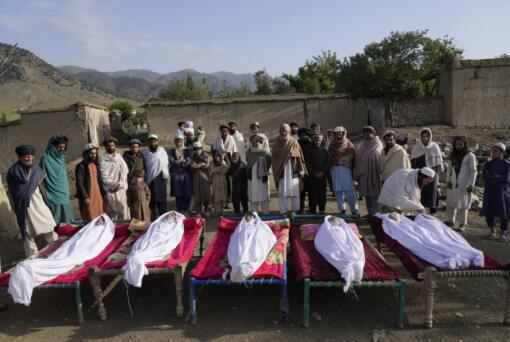 Afghans stand by the bodies of relatives killed in an earthquake in Gayan village, in Paktika province, Afghanistan, Thursday, June 23, 2022. A powerful earthquake struck a rugged, mountainous region of eastern Afghanistan early Wednesday, flattening stone and mud-brick homes in the country's deadliest quake in two decades, the state-run news agency reported.
