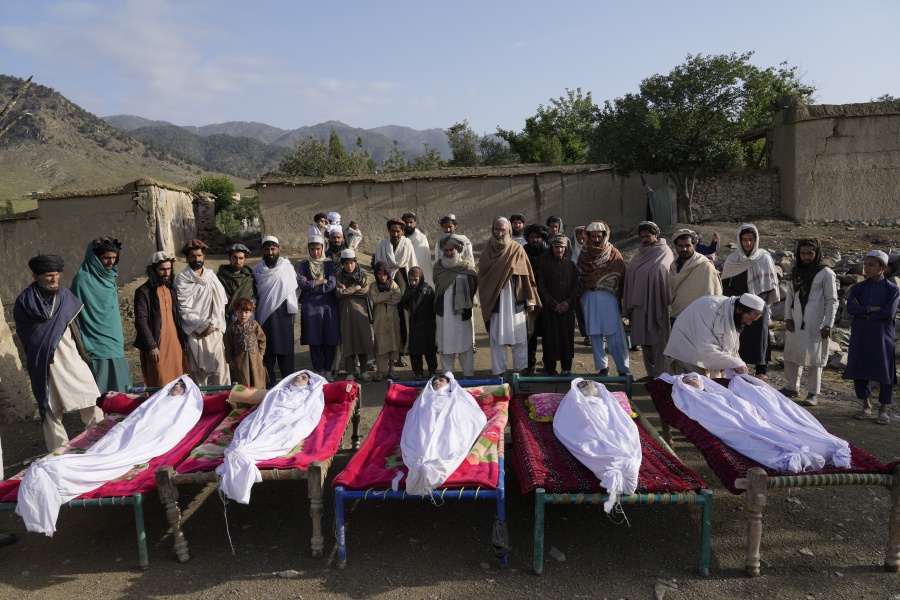 Afghans stand by the bodies of relatives killed in an earthquake in Gayan village, in Paktika province, Afghanistan, Thursday, June 23, 2022. A powerful earthquake struck a rugged, mountainous region of eastern Afghanistan early Wednesday, flattening stone and mud-brick homes in the country's deadliest quake in two decades, the state-run news agency reported.