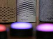 Amazon Echo and Echo Plus devices, behind, sit near illuminated Echo Button devices during an event by the company in Seattle.