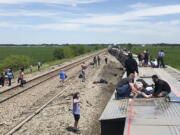 In this photo provided by Dax McDonald, an Amtrak passenger train lies on its side after derailing near Mendon, Mo., on Monday, June 27, 2022. The Southwest Chief, traveling from Los Angeles to Chicago, was carrying about 243 passengers when it collided with a dump truck near Mendon, Amtrak spokeswoman Kimberly Woods said.