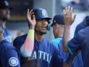 Seattle Mariners' Julio Rodriguez is greeted in the dugout after scoring on a sacrifice hit by Abraham Toro against the Oakland Athletics during first inning of a baseball game, Thursday, June 30, 2022, in Seattle.