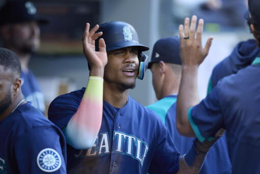 Seattle Mariners' Julio Rodriguez is greeted in the dugout after scoring on a sacrifice hit by Abraham Toro against the Oakland Athletics during first inning of a baseball game, Thursday, June 30, 2022, in Seattle.
