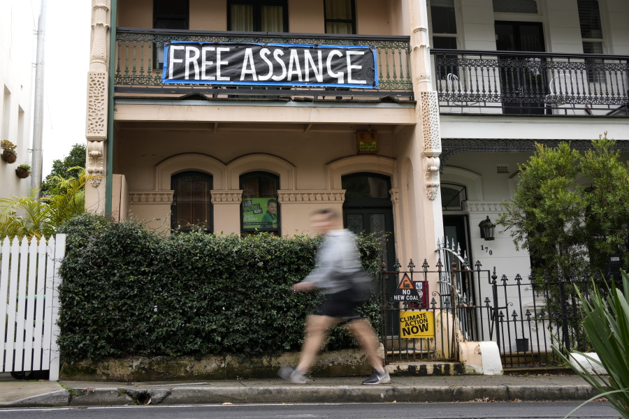 A pedestrian walks past a house with a sign in support of WikiLeaks founder Julian Assange in Sydney, Australia, Monday, June 20, 2022.