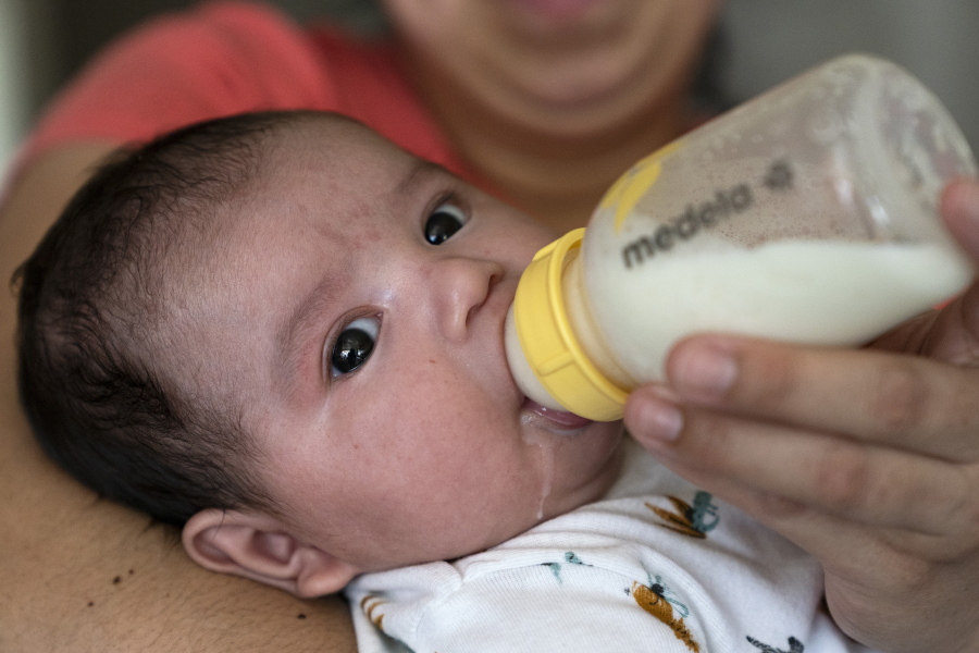 Two-month-old Jose Ismael G?lvez is fed a bottle of formula by his mother, Yury Navas, 29, of Laurel, Md., from her dwindling supply of formula at their apartment in Laurel, Md., Monday, May 23, 2022. After this day's feedings she will be down to their last 12.5 ounce container of formula. Navas doesn't know why her breastmilk didn't come in for her third baby and has tried many brands of formula before finding the one kind that he could tolerate well, which she now says is practically impossible for her to find. To stretch her last can she will sometimes give the baby the water from cooking rice to sate his hunger.