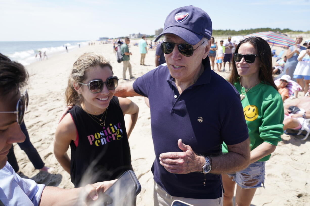 President Joe Biden talks to the media after walking on the beach with his granddaughter Natalie Biden, left, and his daughter Ashley Biden, right, Monday, June 20, 2022 at Rehoboth Beach, Del.