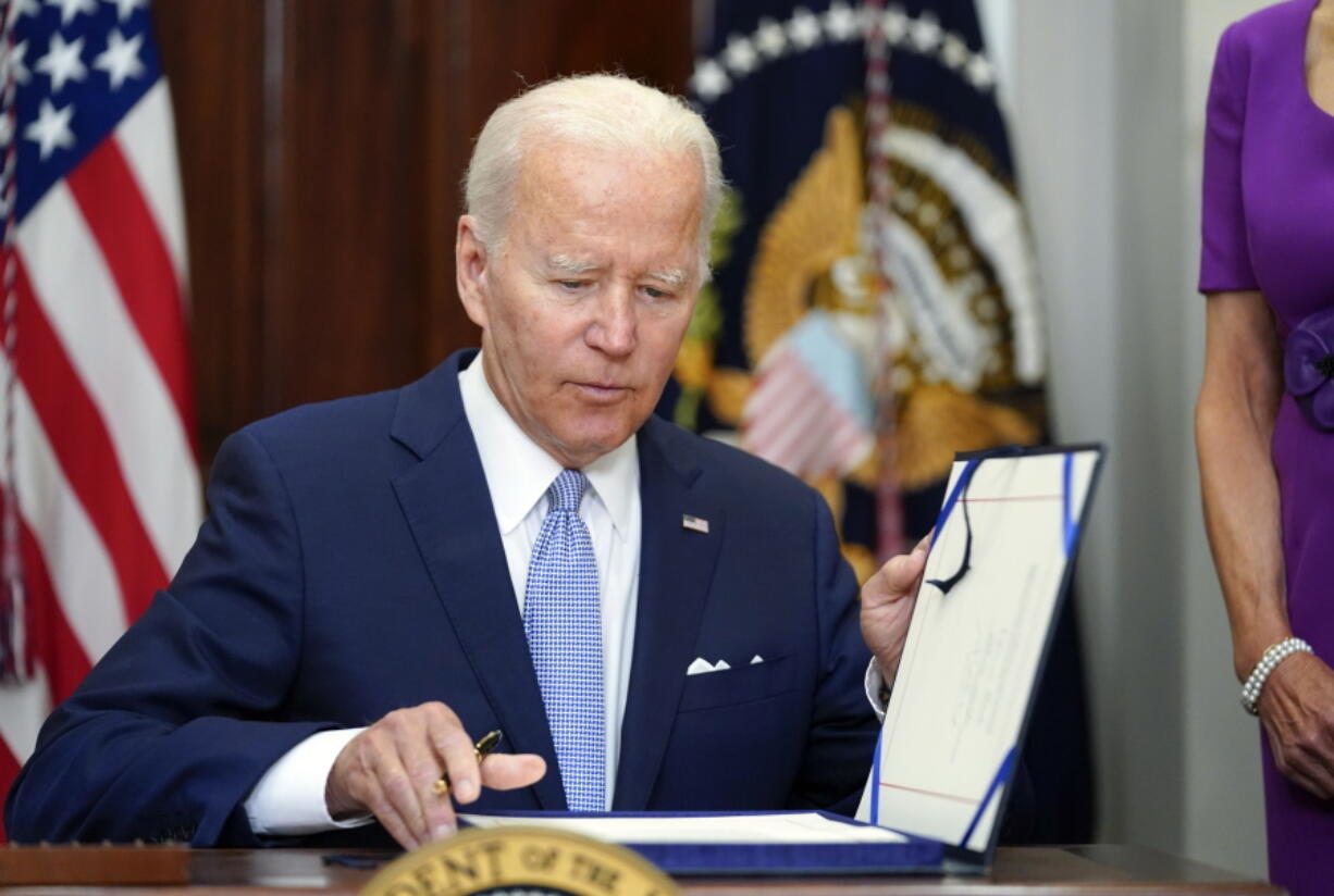 President Joe Biden signs into law S. 2938, the Bipartisan Safer Communities Act gun safety bill, in the Roosevelt Room of the White House in Washington, Saturday, June 25, 2022.