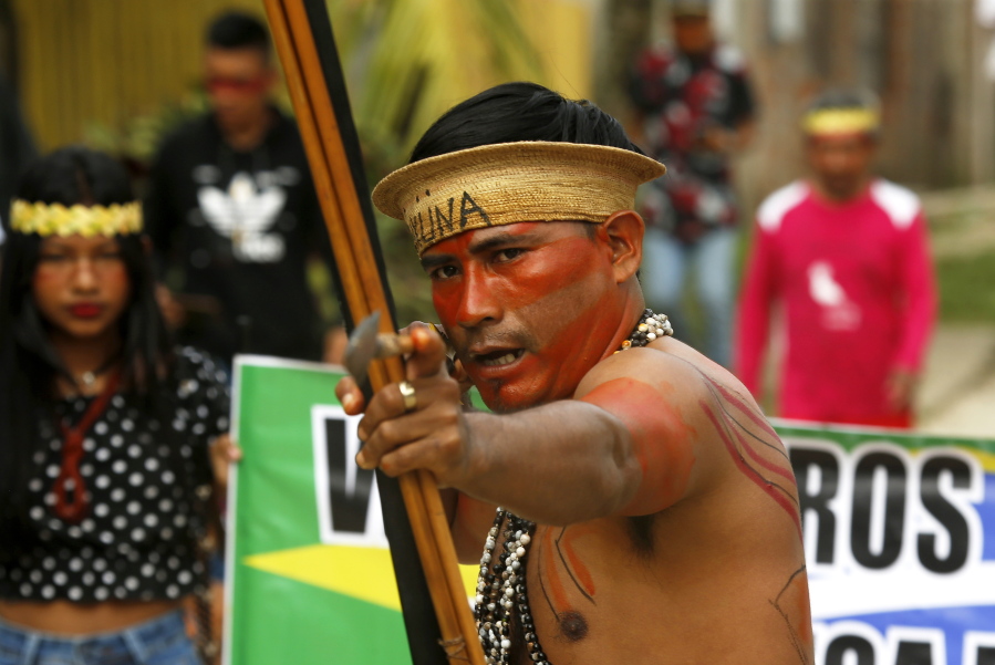 An indigenous man aims an arrow during a protest against the disappearance of Indigenous expert Bruno Pereira and freelance British journalist Dom Phillips, in Atalaia do Norte, Vale do Javari, Amazonas state, Brazil, Monday, June 13, 2022. Brazilian police are still searching for Pereira and Phillips, who went missing in a remote area of Brazil's Amazon a week ago.
