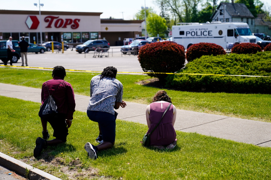FILE - People pray outside the scene of a shooting where police are responding at a supermarket, in Buffalo, N.Y., May 15, 2022. When police confronted Payton Gendron, the white man suspected of killing 10 Black people at the supermarket, he had an AR-15-style rifle and was cloaked in body armor. Yet officers talked to Gendron, convinced him to put down his weapon and arrested him without firing a single shot. Some people are asking why that type of treatment hasn't been afforded to Black people in encounters where they were killed over minor traffic infractions, or no infractions at all.
