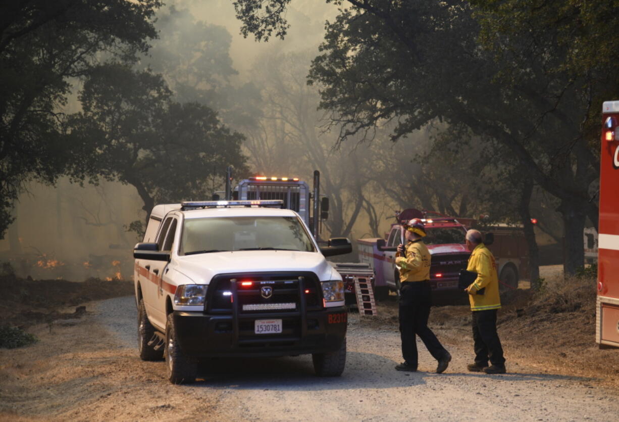 Firefighters coordinate the ground fire attack on the Rices Fire Tuesday, June 28, 2022, off of Troost Trail, in North San Juan, Calif.